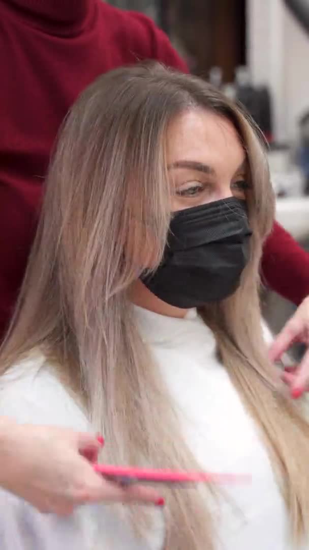 Vertical Video Girl Blond Hair Black Mask Sits While Hairdresser — Stock Video