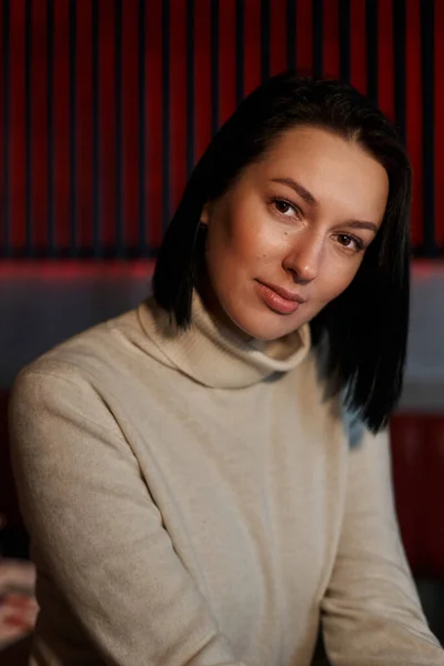 Kırmızı çizgili bir duvarın arkasında güzel bir kızın portresi.