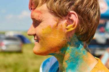 Aleksandrovsky, Rusya 2015.06.21. Yüzü renkli boyalarla kaplı bir adam. Profilde yakın plan resimleri.