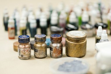 Bir sürü renkli küçük boya şişeleri altın tozuyla boyanmış.