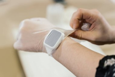 Kadın eli saatli, şeffaf eldivenli.