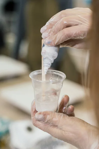 Una Chica Con Guantes Transparentes Vierte Pintura Una Botella Blanca Imagen De Stock