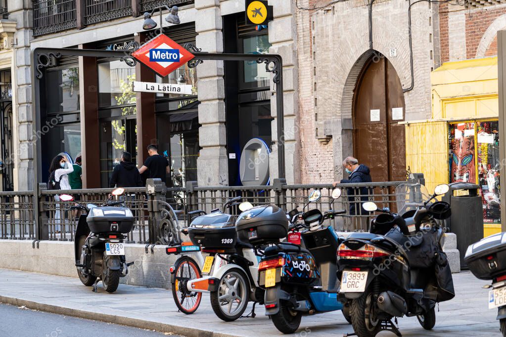 Madrid Spain. April 6, 2021. Motorcycles parked next to the entrance of the La Latina metro station in Madrid