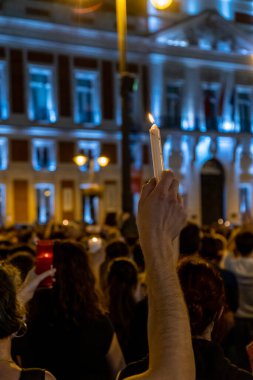 Protestocuların gösterisinde elinde yanan bir mum vardı.