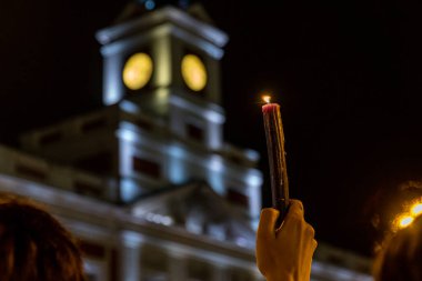 Protestocuların gösterisinde elinde yanan bir mum vardı.