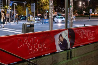 Madrid, İspanya. 1 Aralık 2025. Madrid 'deki İspanya Meydanı metro girişinin editör fotoğrafı, 3. hat tatil treni açılış töreni için David Bisbal Noel posterleriyle süslenmiş..