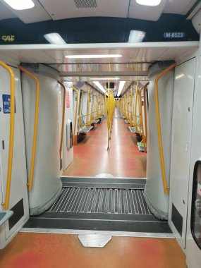 3 Şubat 2026. Madrid, İspanya. Madrid metrosunun 6. hattında çalışan boş bir tren vagonunun içi. Yolcu yok, sarı korkuluklar ve temiz bir merkez koridor var..