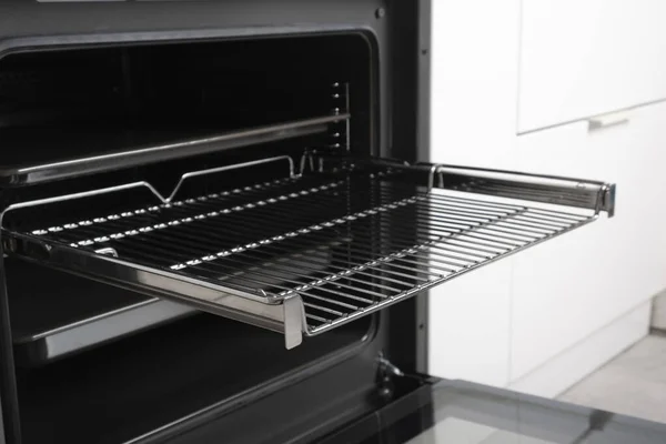 Ekran, toplantı ve ızgara ile siyah üzerine inşa edilmiş yeni modern elektrikli fırın, boş ve açık. Teleskopik rehberler. Beyaz minimalist bir mutfakta İskandinav tarzı.
