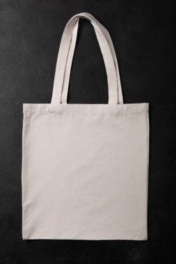 Beyaz alışveriş torbası kumaş kumaş kumaş kumaş eko çanta modeli, siyah desenli arka planda kopyalanmış bir şablon. Düz yatıyordu.
