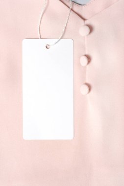 Tasarımınızı yerleştirmek için beyaz giysi etiketi, boş model şablonu. Premium pamuk pembe bluz kumaş arka planda.