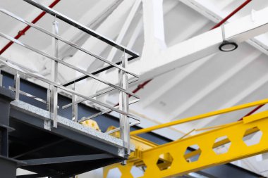 Pürüzsüz çelik korkuluklar, pürüzsüz, parlak yüzey, kare profil. Turna Işını. Endüstriyel uzay santralinde temiz çizgileri olan asgari modern tasarım gri ve siyah iç mimari..