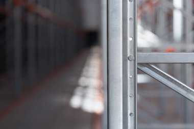 Bir depoda ya da fabrikada endüstriyel metal raflar var. Turuncu kirişli çelik yapı ve metal verimli depolama sistemi. Lojistik endüstriyel tasarım kavramları.