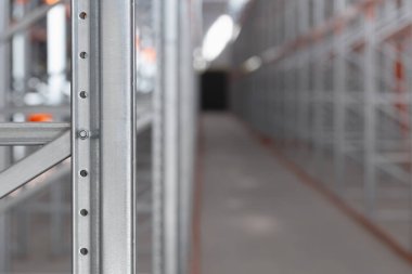 Bir depoda ya da fabrikada endüstriyel metal raflar var. Turuncu kirişli çelik yapı ve metal verimli depolama sistemi. Lojistik endüstriyel tasarım kavramları.