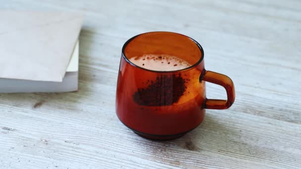 The girl pours instant coffee into a cup of milk and mixes it with a golden spoon. — Stock Video