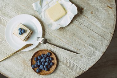 Masada beyaz bir tabakta yaban mersinli ballı pasta