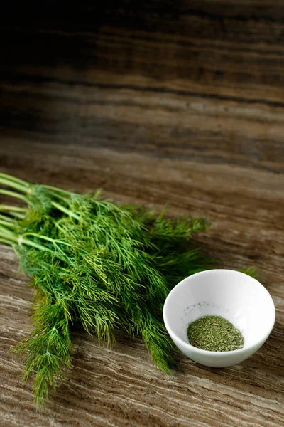 Fresh and dried dill on a wooden board — Stock Photo, Image