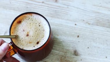 Ahşap bir masada bir fincan aromatik kahve ve peynirli kek var..