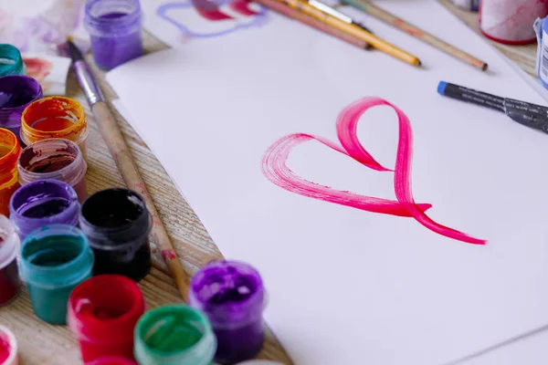 Стіл художника: пензлі, фарби, олівці, олівці, папір. Інструменти малювання та малювання сердець . Стокове Фото