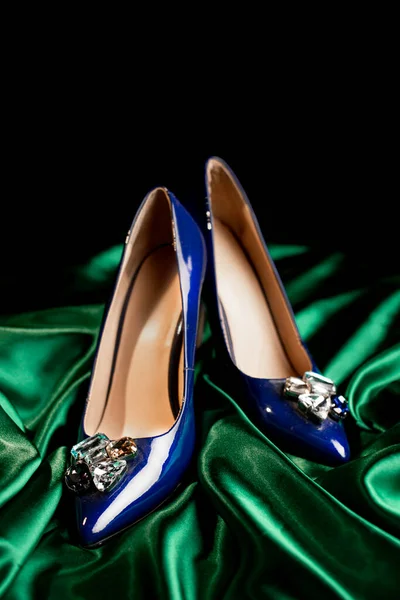 blue womens stiletto heels on a green background