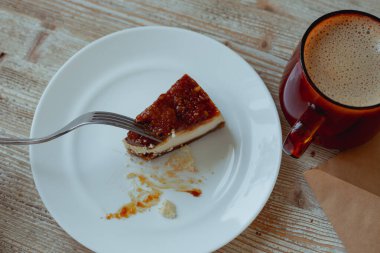 Kahvaltıda çatallı cheesecake ve bir fincan kahve alır.