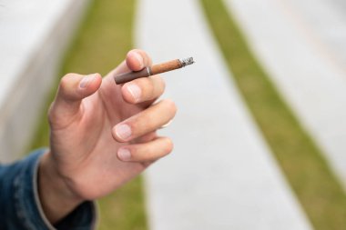 Elinde sigara tutan bir adam.