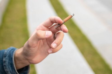 Elinde sigara tutan bir adam.