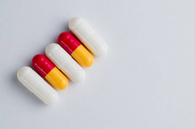 Beyaz arka planda kapsül kabuklu haplardaki tabletlerin makro fotoğrafı