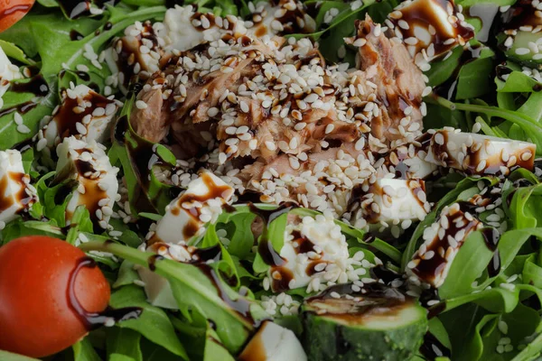 Healthy greens salad on a white plate on a white plate with balsamic sauce, sesame seeds, chicken and arugula — Stock Photo, Image