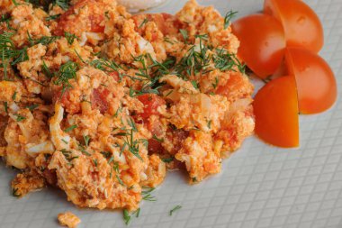 Domatesli omlet, peynir ve beyaz arka planda beyaz tabakta bir sandviç.