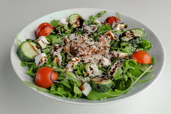 Egészséges zöldség saláta fehér tálcán balzsamos mártással, szezámmaggal, csirkével és arugulával — Stock Fotó