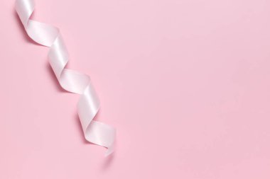 Hediye paketi için pembe kurdele, sağlam pembe bir arka planda.