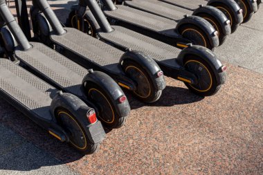 İstasyonda elektrikli scooter, park yerinde elektrikli scooterlar, kiralık ve eğlenceli insanlar.