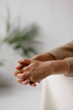 Kilide katlanmış pembe manikürlü güzel kadın elleri.