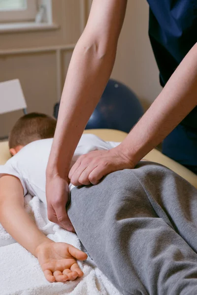 Médico osteopata massagista trata a coluna vertebral após lesão, terapia manual para uma criança — Fotografia de Stock