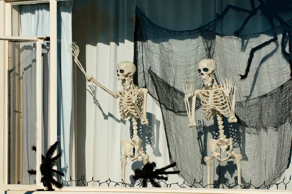Skeletten in het raam. Halloweenlandschap. Vreselijke vakantie thuis. Halloween in de VS. Tradities en huisinrichting. Vreselijke wezens.. — Stockfoto