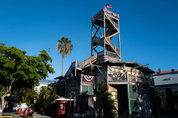 Key West, FL, USA - JUNHO, 2020: Construção de madeira Key West com bandeiras. Bandeira dos EUA no topo de um forte dos EUA. — Fotografia de Stock