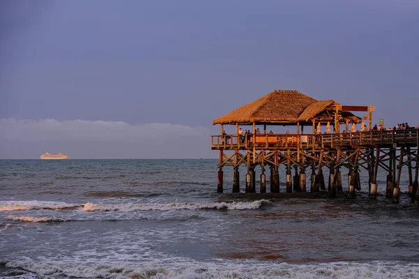Cais de Cocoa Beach ao pôr-do-sol. Pessoas irreconhecíveis caminham perto do oceano. Paradise Beach e Oceano Atlântico por do sol. — Fotografia de Stock