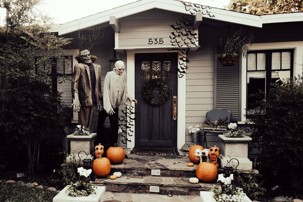 American house decorated for happy Halloween. Dead monsters, zombies and pumpkins.