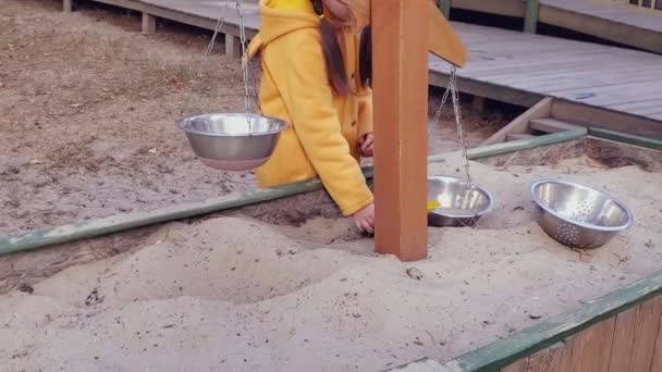 Ein Kleines Mädchen Gelben Pullover Spielt Sandkasten Mit Gewichten Und — Stockvideo