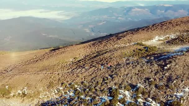 Senderismo turístico en las montañas en otoño e invierno. Los viajeros están caminando. Deportes y actividades recreativas. Senderismo, viajes conjuntos, trekking a lo largo del sendero de montaña. Vista del dron. — Vídeos de Stock