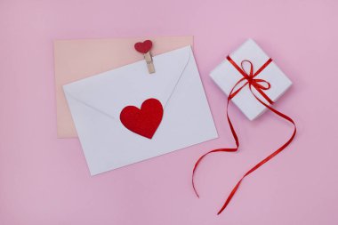 Sevgililer günü için zarf mektup. Kırmızı kalpli kompozisyon ve pembe arka planda Sevgililer Günü için hediye kutusu. Aşk ilanı. Aşk ve ilişkiler kavramı