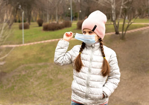 Kleines Mädchen Setzt Beim Spazierengehen Park Eine Medizinische Schutzmaske Auf — Stockfoto