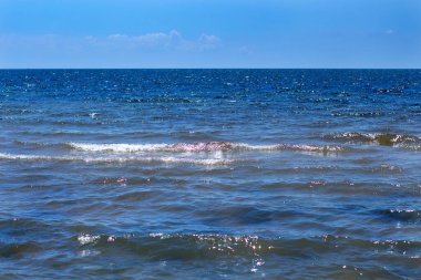 Sea surface with waves against the blue sky with clouds. Water cloud horizon background. 