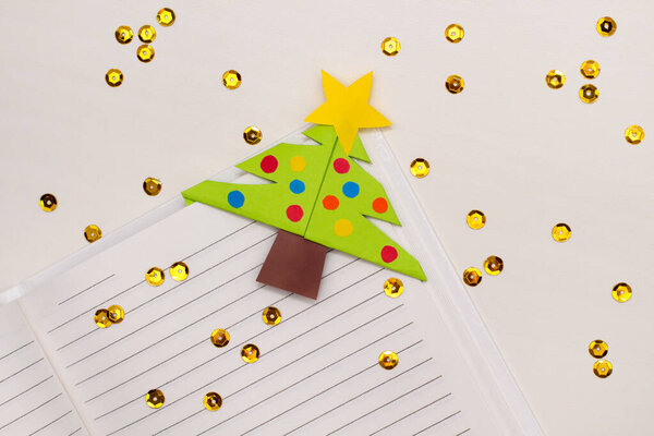 Step-by-step instructions for making Christmas Tree Corner Bookmarks. DIY. Creative origami ideas for kids. Top view, flat lay. Step 7 - final result