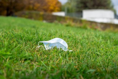 Yeşil çimlerin üzerinde koruyucu bir yüz maskesi var..