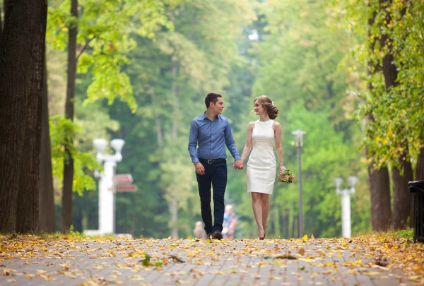 История любви, молодой человек и женщина любят друг друга, они гуляют в парке, целуются и обнимаются — стоковое фото