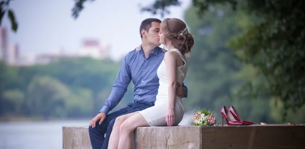 Eine Liebesgeschichte, ein junger Mann und eine junge Frau lieben einander, sie gehen durch den Park, küssen und umarmen sich — Stockfoto