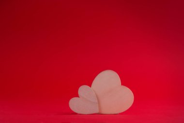 Kırmızı arka planda iki tahta kalp. Sevgililer Günü konsepti. Yan görüş. Yatay format. Kopyalama alanı