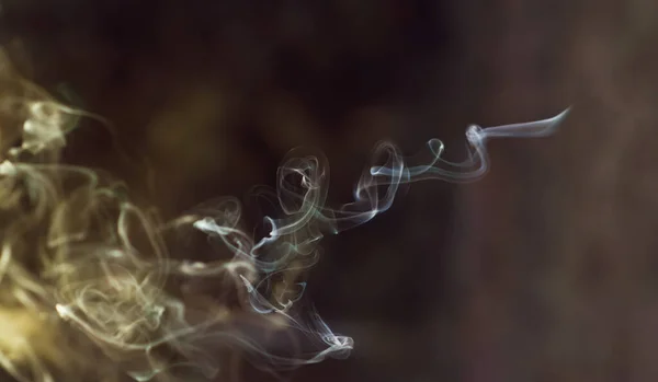 Un hermoso soplo de humo se disipa en el aire. Mucho humo al atardecer al aire libre. Formato horizontal. Espacio de copia — Foto de Stock