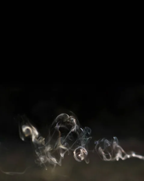Hermoso humo de incienso con reflejo sobre un fondo negro. Banner de diseño. Formato vertical. Espacio de copia — Foto de Stock